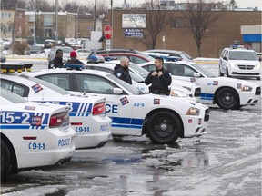 Police congregate in a parking lot at Place Bourassa shopping centre near Montreal police station 39 on Henri Bourassa Blvd. in Montreal North, Thursday April 7, 2016.  There was a heavy police presence in the area after a small riot overnight following a peaceful demonstration that resulted in torched cars and vandalized buildings including the police station.