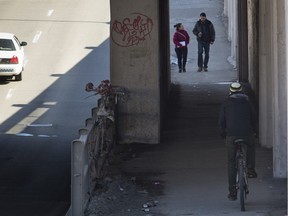 A cyclist uses the sidewalk at the St-Denis St. underpass at des Carrières St.