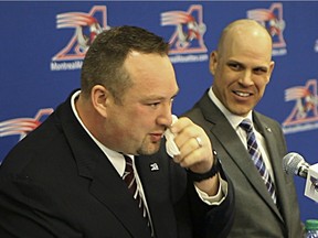 Alouettes veteran Scott Flory wipes a tear while announcing his retirement during a news conference at the Olympic Stadium on May 7, 2014, as Alouettes president Mark Weightman looks on.