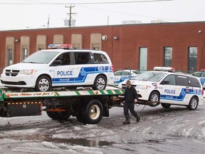A tow truck operator prepares a vandalized police car outside Montreal police Station 39 in Montreal North, April 7, 2016. A small riot following a peaceful demonstration resulted in torched cars, vandalized buildings including the police station.