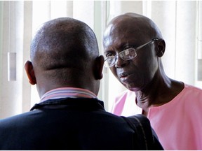 Former politician Léon Mugesera (R) talks to his legal counsel at the courthouse in Kigali on Friday.  A Rwandan court on April 15, 2016 sentenced Mugesera to life in prison for inciting the 1994 genocide. Judge Antoine Muhima said Mugesera had taken part in "public incitement to commit genocide" as well as inciting torture and ethnic hatred, though he was found not guilty of planning and conspiracy to commit genocide.