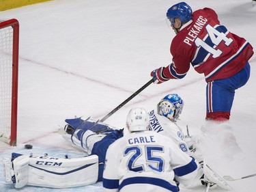 Montreal Canadiens' Tomas Plekanec (14) scores against Tampa Bay Lightning goaltender Andrei Vasilevskiy as Lightning's Matthew Carle defends during first period NHL hockey action in Montreal, Saturday, April 9, 2016.