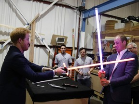 Prince Harry, left, and Prince William find their weapon of choice on a tour of the Star Wars set at England's Pinewood Studios.