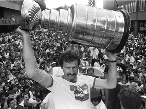 Canadiens defenceman Larry Robinson hoists the Stanley Cup, on Atwater St. outside of the fabled Montreal Forum (at right) on Monday, May 26, 1986. An estimated 500,000 fans lined the parade route for about five hours for a chance to see the 1986 Stanley Cup winners. parade following the Canadiens' victory in 1986. Robinson won six Cups with Habs.
