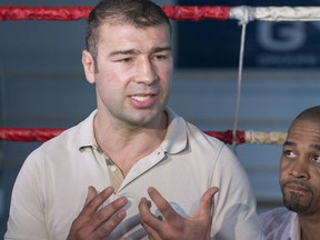 Boxer Lucian Bute, left, speaks to reporters in Montreal, Friday, May 27, 2016, as trainer Howard Grant looks on following Bute's positive test for a banned substance.
