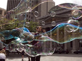 Robert, who is known as "The Bubble Wizard", entertains kids in Old Montreal Friday, July 24, 2015 in Montreal. A recent incident in New York City has sparked debate about etiquette between tourists and street performers.