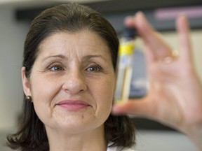 Director Christiane Ayotte holds up a urine sample at the National Scientific Research Institute in Laval, Que., Wednesday, Jan.13, 2010. A Montreal-area doping-control expert says it is not surprising that 31 new doping cases have been discovered in retested samples taken from athletes during the 2008 Summer Olympics.