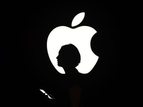 (FILES) This file photo taken on September 9, 2015 shows a reporter walking by an Apple logo during a media event in San Francisco, California. Global sales of tablet computers extended their slide in early 2016, with some bright spots at the low end of the market and more expensive "detachables," a survey showed April 28, 2016.Overall sales of tablets fell 14.7 percent in the first quarter to 39.6 million units, continuing a downward trend from 2015 when the once-hot market cooled, said the survey by research firm IDC.  /