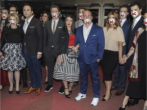 Comedians arrive on the red carpet wearing masks to protest alleged censorship at the Olivier Awards gala in Montreal, Sunday, May 15, 2016.