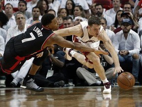 Miami Heat guard Goran Dragic (7) takes control of a loose ball from Toronto Raptors guard Kyle Lowry (7), during the first half of Game 3 of an NBA second-round playoff basketball series Saturday, May 7, 2016, in Miami.