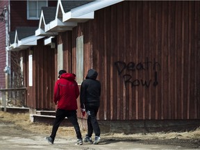 Indigenous people walk through the streets in the northern Ontario First Nations reserve in Attawapiskat, Ont., on Wednesday, April 20, 2016.