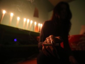 A sex worker smokes a cigarette at an undisclosed location.