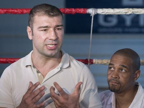 Boxer Lucian Bute, left, speaks to reporters in Montreal, Friday, May 27, 2016, as trainer Howard Grant looks on following Bute's positive test for a banned substance.