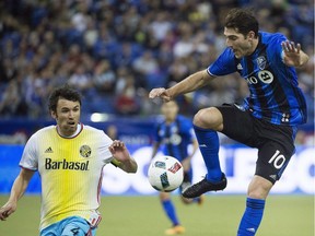 Montreal Impact's Ignacio Piatti, right, challenges Columbus Crew SC's Michael Parkhurst (4) during first half MLS soccer action in Montreal on April 9, 2016. Montreal Impact midfielder Ignacio Piatti has been named Major League Soccer's player of the week. Piatti scored two goals and drew a penalty kick converted by Didier Drogba in the Impact's 4-4 draw in Columbus on Saturday.