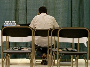 A sole candidate sits at an interview table at a job fair.