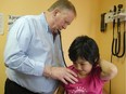 Dr. John Harrold, a family physician, listens to the heart beat of a five-year-old child as he performs a check up.