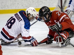 Team Canada Sledge Hockey forward Mathieu Trudeau, right, battles with Team USA's Vlad Lundquist on Sunday. Team USA defeated Team Canada 5-0.