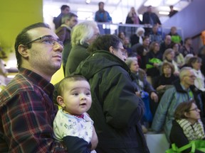Afshin Rezaei and his daughter Adrein take in the sights during a presentation at an open door event at the N.D.G. Cultural Centre and Benny Library in Montreal Saturday, February 6, 2016.