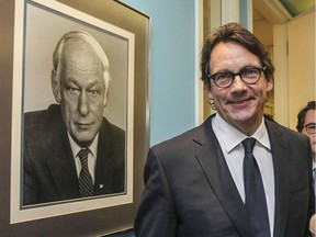 Pierre Karl Péladeau, who quit as Parti Québécois leader on May 2, 2016, stands next to a portrait of the PQ's first leader, René Lévesque, at the party's office in Montreal on Jan. 28, 2016.