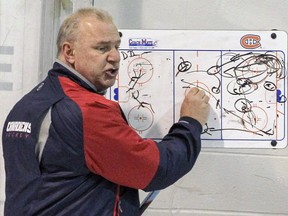 Canadiens coach Michel Therrien outlines drills on a white board during practice at the team's training facility on March 9, 2016.