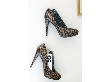 A pair of women's pumps fixed to the wall next to Judith Lessard and Wallace Lee's bed hold various remote controls for the TV and electronics in the master bedroom of their penthouse apartment. (John Mahoney / MONTREAL GAZETTE)
