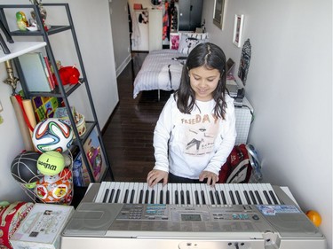 Judith Lessard and Wallace Lee's daughter Jena practices at the keyboard in her narrow bedroom. (John Mahoney / MONTREAL GAZETTE)