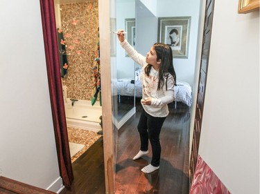 Jena draws on the whiteboard on the pivoting door that separates her bedroom from the rest of the penthouse apartment. The door can also swing to close off the bathroom at left. (John Mahoney / MONTREAL GAZETTE)
