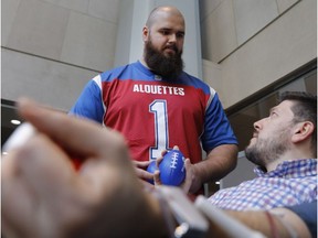 Philippe Gagnon, who was the Alouettes' first selection (No. 2 overall) in this year's CFL draft, chats with Elias Makos as he donates blood during the team's annual blood drive at Place Ville Marie.