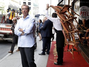 Alain Creton, owner of Alexandre et fils, watches as city workers return his chairs after attempting to seize them in Montreal on Thursday May 12, 2016. The city and the café are in a dispute over where the terrace should be installed. The city's choice would mean 3 times the cost for the Chez Alexandre restaurant owner.
