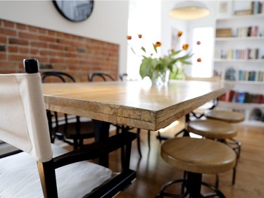Fresh flowers sit on a large wooden dining room table. (Allen McInnis / MONTREAL GAZETTE)