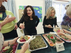 Afra Jalabi, right, and her sister Arwa, left, serve Syrian food to people at the Cedar Park United church in Pointe-Claire on Friday, May 13, 2016. The sisters served Syrian delicacies they cooked themselves during a fundraising event at the church. The money will go towards sponsoring a family of their relatives. (John Kenney / MONTREAL GAZETTE)
