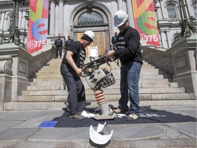 Demonstrators crush construction helmets during a protest by striking Montreal city engineers and supporters outside Montreal city hall, May 17, 2016.