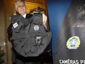 Richard Lafond, in charge of special projects for SPVM, holds a police officer vest with a body camera during a presser at the Montreal City Hall on May 18, 2016. The city of Montreal and the Montreal police, (SPVM) launched a pilot project where about thirty police officers at first will be wearing body cameras to monitor their interactions. It is a first in Quebec.