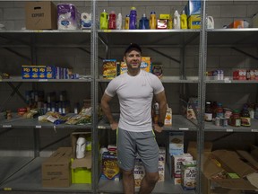 West Island Mission volunteer Chris Cigos stands in front of half-empty shelves at its food bank in Pointe-Claire on Saturday, May 21, 2016. (Peter McCabe / MONTREAL GAZETTE)