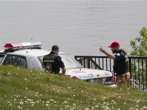 A pair of Montreal police officers at the scene near the St Lawrence River where Coast Guard officials found a body washed up, in Pointe-aux-Trembles.