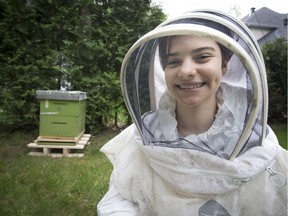 Alexis Ciarello and her new bee hive – with its 5,000 bees – she received as a birthday gift at her home in St-Lazare.  (Peter McCabe / MONTREAL GAZETTE)