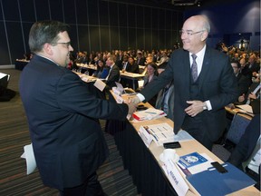 Montreal mayor Denis Coderre, left, greets Quebec transport minister Jacques Daoust after Coderre gave a speech at Palais des congrès in Montreal, Friday, May 6, 2016 at the opening of a Montreal Chamber of Commerce forum on transportation.