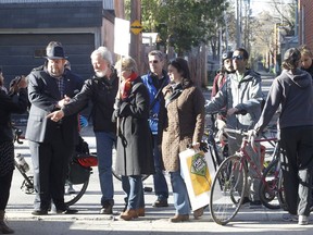 Benoit Dorais, mayor of South West borough, far left, listens to neighbours who show him where a  six-hear-old boy on his bicycle was hit by a truck coming out of an alley. They were among neighbours, city councillors and a cycling group who held a protest on May 9, 2016 for safer streets in Cote- St-Paul.