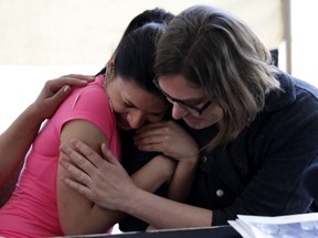 Gilda Lakatos, 17, left, hugs Mary Foster of Solidarity Across Borders after the group held a news conference in Montreal on Tuesday, May 10, 2016.