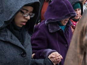 Wearing purple, Samia Ali Messouad, the wife of murdered taxi driver Ziad Bouzid, is helped to a vehicle from the Islamic Centre of Montreal, Nov. 26, 2013.