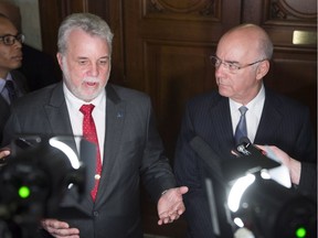 Quebec Premier Philippe Couillard announces the resignation of Transport deputy minister Dominique Savoie as Quebec Transport Minister Jacques Daoust , right, looks on, May 19, 2016, in Quebec City.