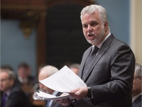 Quebec Premier Philippe Couillard responds to Opposition questions over contracts given by the Transport Ministry, holding documents he is about to table, Wednesday, May 18, 2016 at the legislature in Quebec City. A Leger survey suggests nearly 70 per cent of Quebecers are dissatisfied with the Quebec Liberals.