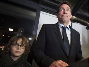 Pierre Karl Peladeau gives a speech as his son Thomas looks on at a restaurant in St-Jerome, Que. after winning his PQ seat on Monday, April 7, 2014.