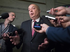 Former Transport minister Robert Poëti responds to reporters questions Wednesday, May 18, 2016 at the legislature in Quebec City.