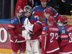 Russia's goalie Sergei Bobrovski is comforted by teammate Sergei Shirokov, left, after their team lost the Ice Hockey World Championships semifinal match between Finland and Russia, in Moscow on Saturday, May 21, 2016.