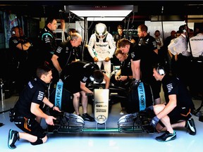 Mercedes crew members attend to Lewis Hamilton's car during practice for the Spanish Grand Prix.
