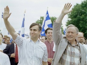 Jacques Parizeau and Lucien Bouchard wave to the crowd as they march in the St. Jean Baptiste Day parade in 1995.