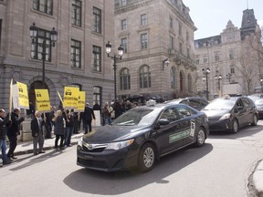 Taxi drivers demonstrate outside the Premier's office as the cabinet meets at the Quebec Legislature, in Quebec City on Wednesday, May 4, 2016. The taxi industry is putting pressure on the government to ban Uber and other ride-sharing companies from their industry.