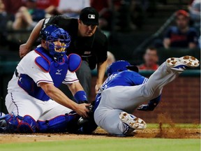 Catcher Bobby Wilson of the Texas Rangers tags out Ezequiel Carrera of the Toronto Blue Jays at home during the fifth inning of a baseball game at Globe Life Park on May 14, 2016, in Arlington, Tex.