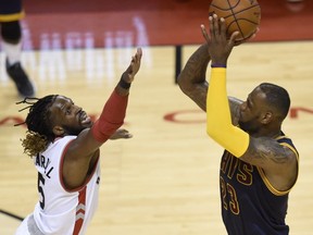 Toronto Raptors forward DeMarre Carroll defends against Cleveland Cavaliers forward LeBron James during second half Eastern Conference final NBA playoff basketball action in Toronto on Saturday, May 21, 2016.